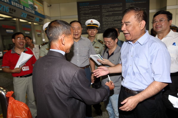 If you're caught smoking against city regulation, what can you do? This man tried off ering a cigarette to a Guangzhou official, who said 'no thanks.' [Photo by Zou Wei/for China Daily]