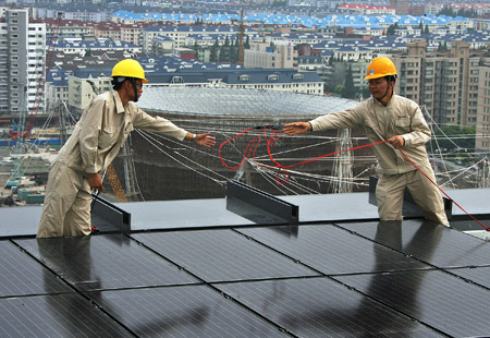 Workers fix solar energy panels on the top floor of the Chinese Pavilion at the Shanghai Expo Site, Shanghai, east China, July 25, 2009. 1,264 solar energy panels will be fixed on the top floor of the Chinese Pavilion, which could generate 300 kilowatt-hours of electricity per hour in the sunny days.