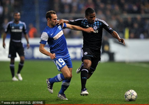  Florent Malouda of Chelsea is challenged by Thomas Buffel of KRC Genk during the UEFA Champions League Group E match between KRC Genk and Chelsea at the KRC Genk Arena on November 1, 2011 in Genk, Belgium.