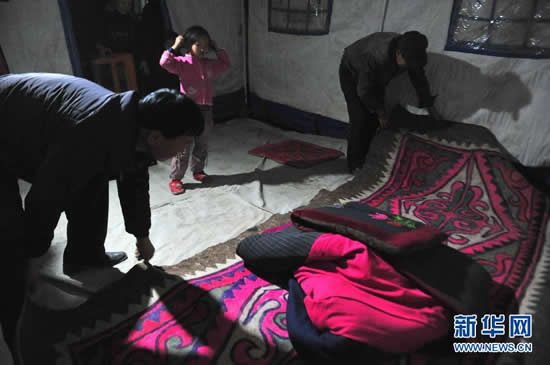 A local official (left) helps villagers spread carpets in the earthquake-hit prefecture in Xinjiang Uygur Autonomous Region on November 1.