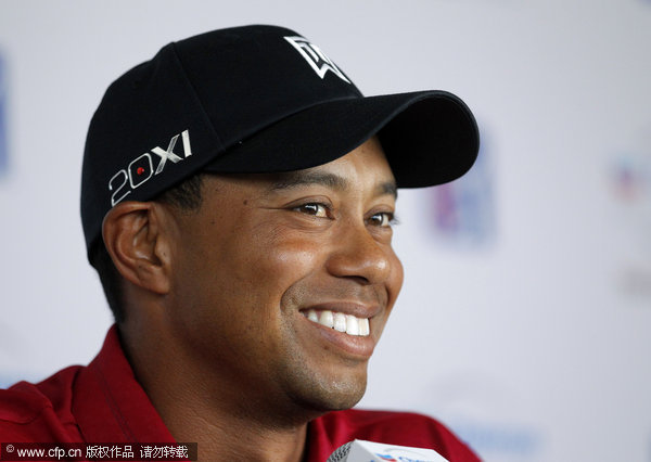 Tiger Woods smiles while answering a question from the media during a news conference held to announce the field for the Chevron World Challenge Golf tournament in Los Angeles on Tuesday, Oct. 11, 2011.