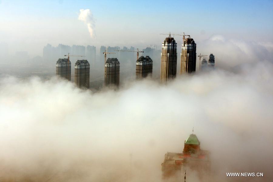 Buildings are seen amid fog in Harbin, capital of northeast China's Heilongjiang Province, Nov. 6, 2011. Local meteorological department issued a 'yellow' fog alert on Sunday. China has a color-coded weather warning system: red, orange, yellow and blue. Blue is the least serious level. [Xinhua]