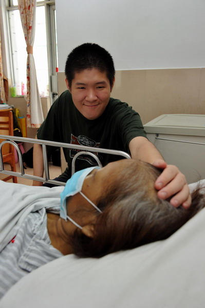 Peng Si caresses his mother's head at a hospital in Guangzhou, South China's Guangdong province on Sep 10, 2011. 