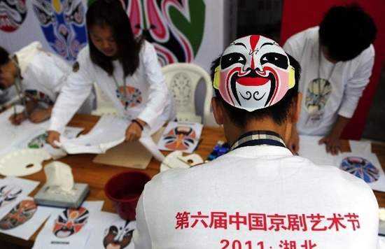 Students majored in Art draw Peking Opera facial masks on T-shirts during the 6th China Peking Opera Art Festival in Wuhan, capital of central China's Hubei Province, Nov. 3, 2011. [Xinhua/Hao Tongqian]