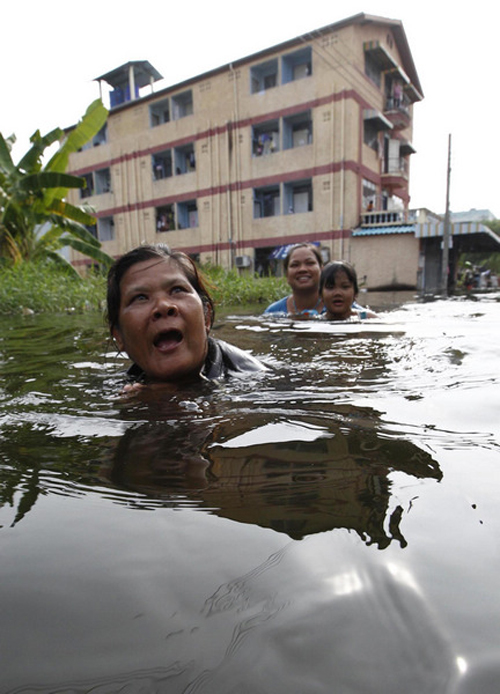 Residents walk through a flooded street in Bangkok Nov 5, 2011. Thailand's worst floods have left 506 people dead and 2 missing, Thai Department of Disaster Prevention and Mitigation reported on Sunday.