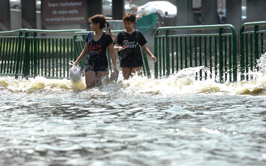 People wade through floodwaters at an inundated street in Thai capital Bangkok Nov. 6, 2011. Thailand's worst floods have left 506 people dead and 2 missing, Thai Department of Disaster Prevention and Mitigation reported on Sunday.