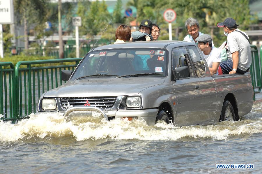 People sit in a pickup truck at an inundated street in Thai capital Bangkok Nov. 6, 2011. Thailand's worst floods have left 506 people dead and 2 missing, Thai Department of Disaster Prevention and Mitigation reported on Sunday.