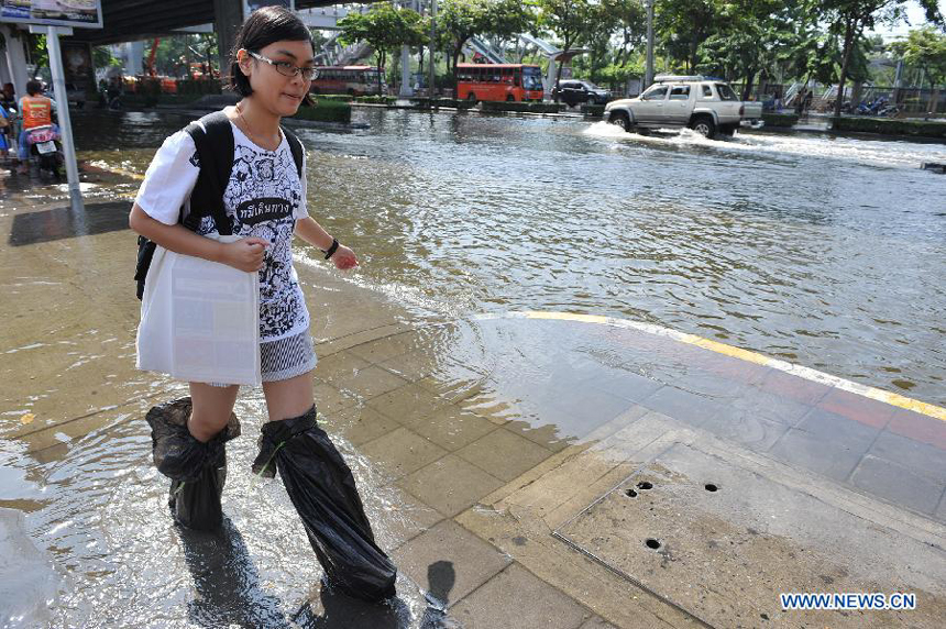 A woman walks through floodwaters at an inundated street in Thai capital Bangkok Nov. 6, 2011. Thailand's worst floods have left 506 people dead and 2 missing, Thai Department of Disaster Prevention and Mitigation reported on Sunday.