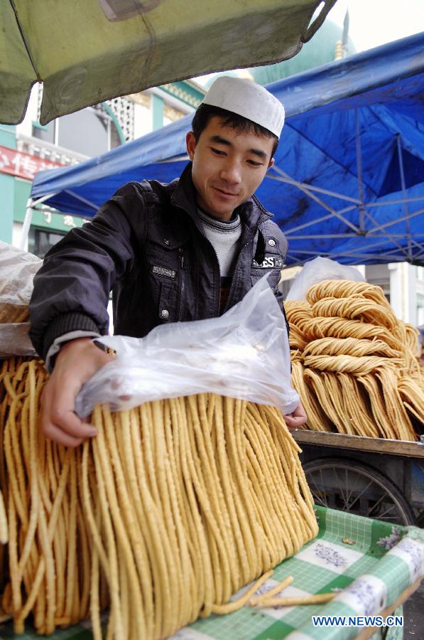 A vender sells Sanzi, or deep-fried dough twists, in Yinchuan, capital of Ningxia Hui Autonomous Region, Nov.6, 2011. Muslims in northwest China celebrated their traditional feast of Corban Festival, or Eid al-Adha Sunday.