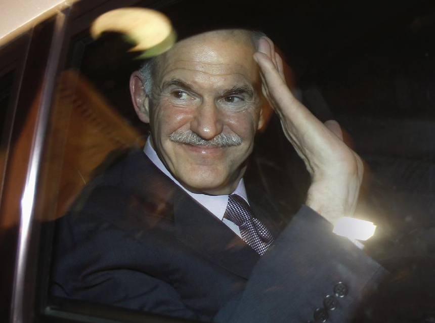 Greek Prime Minister George Papandreou waves from his car as he leaves the presidential palace after a meeting with President Karolos Papoulias and Conservative leader Antonis Samaras in Athens November 6, 2011. Greek Prime Minister George Papandreou and opposition leader Antonis Samaras have agreed on a new coalition government to approve a euro zone bailout deal before elections, the office of the country's president said on Sunday.