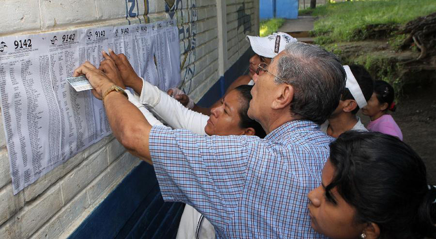 Voters look for their names on the registration list at a polling station in Managua, capital of Nicaragua, Nov. 6, 2011. Nicaraguans went to the polls Sunday to choose their country's president, vice president, 90 deputies of the National Assembly and 20 Central American parliamentarians.