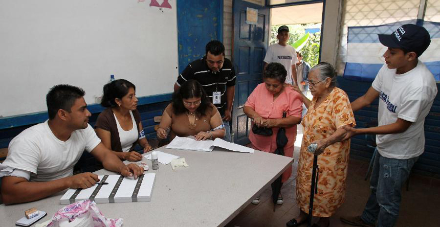 Two elderly voters are helped to cast their ballots at a polling station in Managua, capital of Nicaragua, Nov. 6, 2011. Nicaraguans went to the polls Sunday to choose their country's president, vice president, 90 deputies of the National Assembly and 20 Central American parliamentarians.