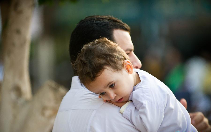 A man holds his child prior to the pray for the Eid al-Adha in front of Mostafa Mahmoud mosque in Cairo, Egypt, Nov. 6 ,2011.