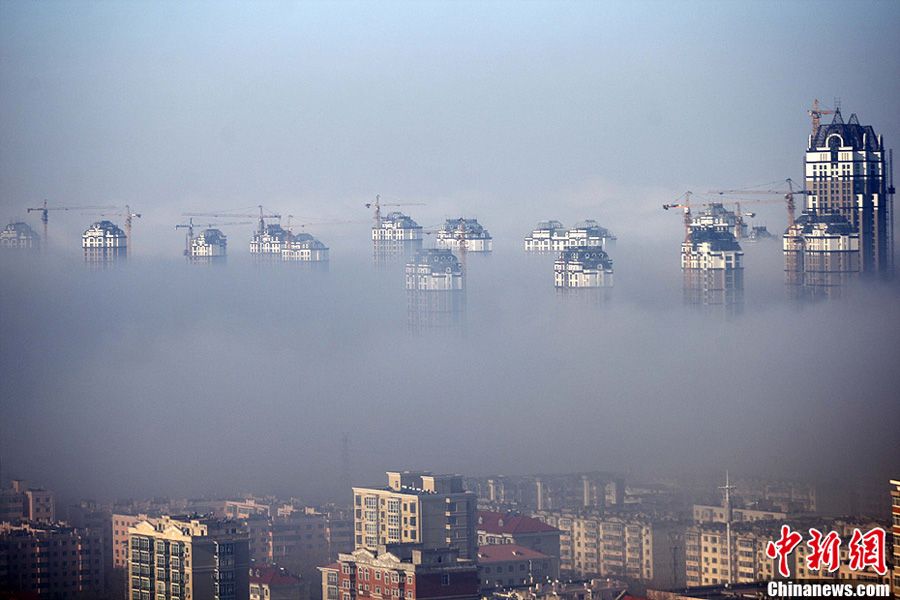 Buildings are seen amid fog in Harbin, capital of northeast China's Heilongjiang Province, Nov. 6, 2011. Local meteorological department issued a 'yellow' fog alert on Sunday. China has a color-coded weather warning system: red, orange, yellow and blue. Blue is the least serious level. 