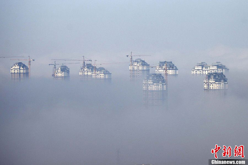 Buildings are seen amid fog in Harbin, capital of northeast China's Heilongjiang Province, Nov. 6, 2011. Local meteorological department issued a 'yellow' fog alert on Sunday. China has a color-coded weather warning system: red, orange, yellow and blue. Blue is the least serious level. 
