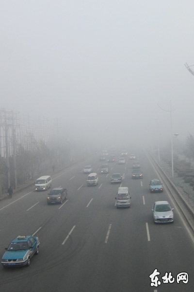 Road and vehicles are seen amid fog in Harbin, capital of northeast China's Heilongjiang Province, Nov. 6, 2011. Local meteorological department issued a 'yellow' fog alert on Sunday. China has a color-coded weather warning system: red, orange, yellow and blue. Blue is the least serious level.