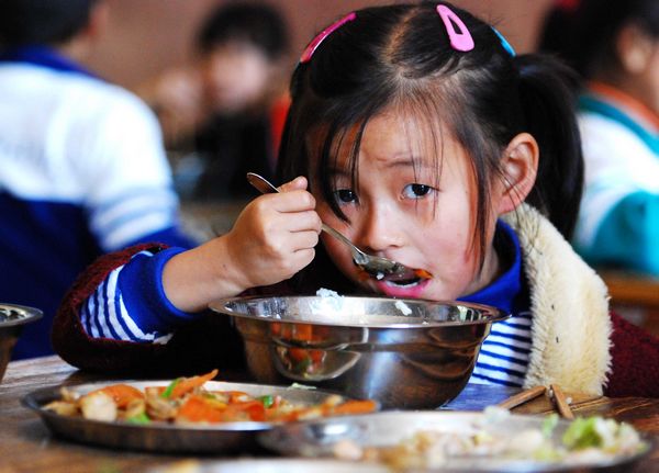Fu Liyuan, a second grader at the Sishan Wanquan Primary School in Duchang county, East China's Jiangxi province, has free lunch in her classroom on Oct 31. [Photo / Xinhua]