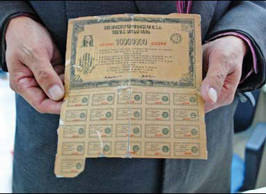 Zhang, a 62-year-old villager from Weifang, East China's Shandong province, holds what he claims is a $10-million US Treasury bond that has been in his family since the 1930s. [Photo / China Daily]