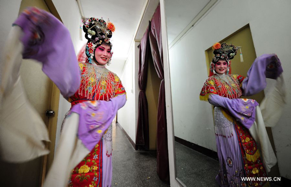 Amateur Peking Opera actress Wang Jun warms up backstage before a performance in Wuhan, central China's Hubei Province, Nov. 4, 2011. Dozens of Peking Opera fans from China and abroad held a show during the ongoing sixth Peking Opera Festival here Friday. 