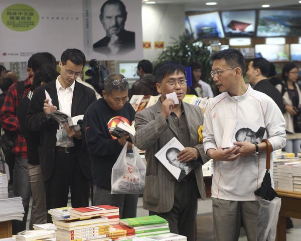 Fans of Steve Jobs queue up to pay for his biography in a bookstore in Shanghai on Oct 24.[Photo/China Daily]