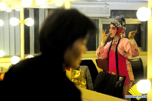 Stephanie Willing, a member of Qi Shufang Peking Opera Troupe, rehearses in front of mirror before performance during the 6th China Peking Opera Art Festival in Wuhan City, capital of central China's Hubei Province, Nov. 8, 2011.