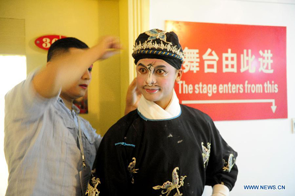 Timoteo Kaniela Hew Len (R), a member of Qi Shufang Peking Opera Troupe, wait for entering on the stage during the 6th China Peking Opera Art Festival in Wuhan City, capital of central China's Hubei Province, Nov. 8, 2011. 