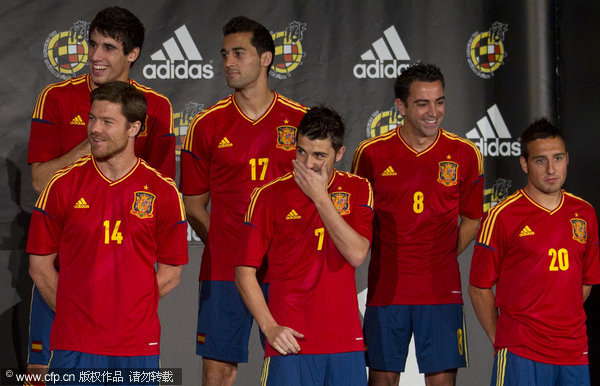 Spain's national soccer team players pose with the new design team shirts during a presentation on the outskirts of Madrid on Thursday, Nov. 10, 2011. 