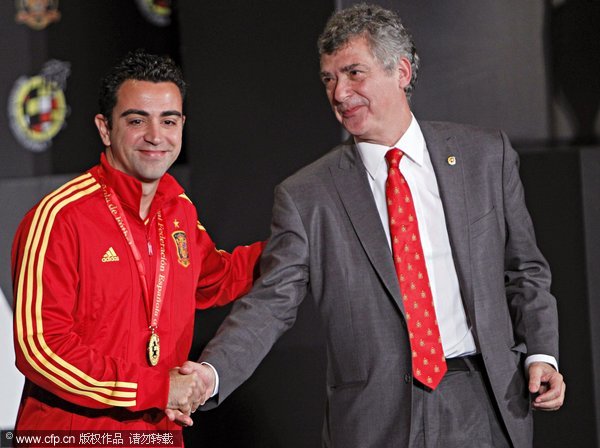 Spanish national soccer team midfielder Xavi Hernandez (L) shakes hands with Spanish Soccer Federation President Angel Maria Villar (R) after he was awarded the Federation's golden medal for playing more than 100 international matches during a ceremony at Soccer City in Las Rozas, outside Madrid, Spain, 10 November 2011. 