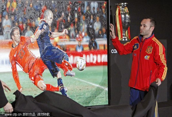 Spanish national soccer team midfielder Andres Iniesta unveils a painting depicting the winning goal he scored in the FIFA World Cup 2010 final against the Netherlands during a ceremony at Soccer City in Las Rozas, outside Madrid, Spain, 10 November 2011. 