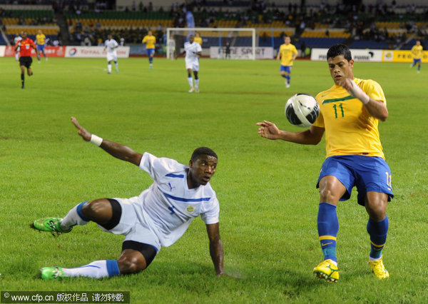 Brazil's Hulk (right) controls the ball past Gabon's Remy Ebanega during the inaugural match at the Gabonese Friendship stadium in Libreville, Gabon on Thursday, Nov. 10, 2011.