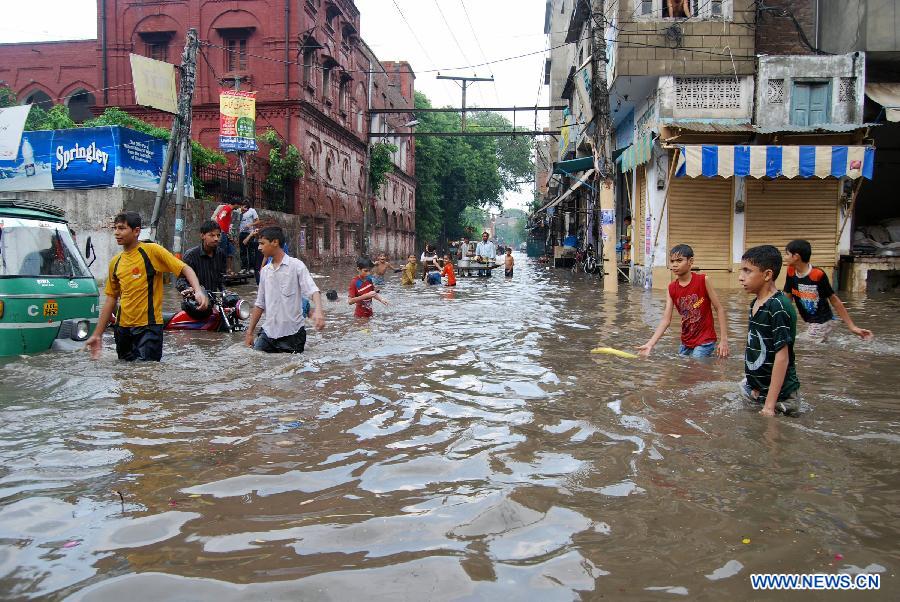 Pakistani people walk in a flooded street after heavy rainfall in eastern Pakistan's Lahore on Nov. 10, 2011. According to the Meteorological Office, cold wave would continue for two to three days, which would drop the temperature further in Lahore.