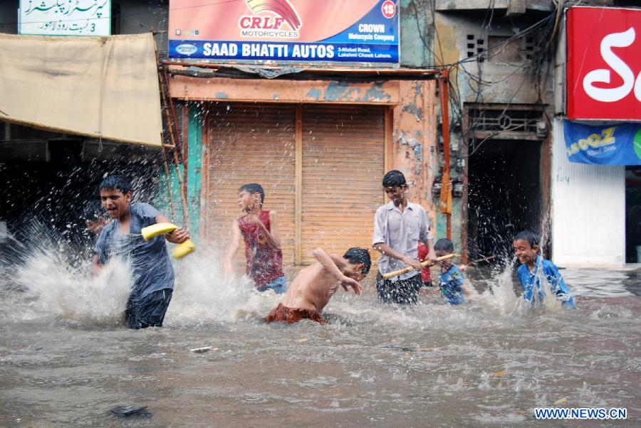 Pakistani children play in a flooded street after heavy rainfall in eastern Pakistan's Lahore on Nov. 10, 2011. According to the Meteorological Office, cold wave would continue for two to three days, which would drop the temperature further in Lahore.