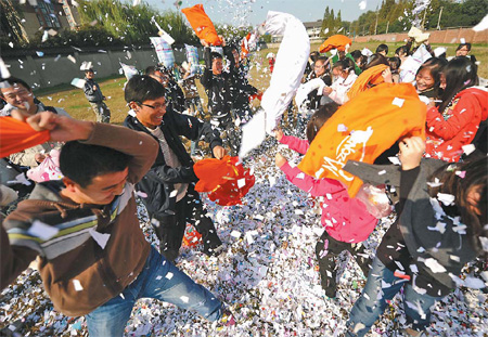 Students at Yangzhou University in East China's Jiangsu province indulge in pillow fights as they prepare to mark Singles' Day on Friday.[Photo/China Daily]
