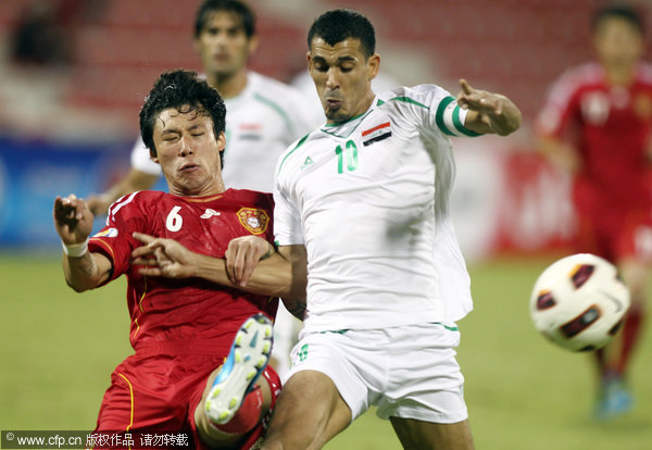 Iraq's Younus Mahmood (right) fights for the ball against China's Zhang Linpehg during their 2014 World Cup Asian qualifying football match a t Al-Arabi Stadium in Doha on Friday, Nov. 11, 2011