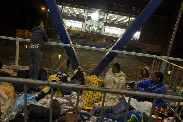 Apple fans wait outside an Apple store in Hong Kong before the new iPhone 4S goes on sale at 7am on Friday. [CFP]
