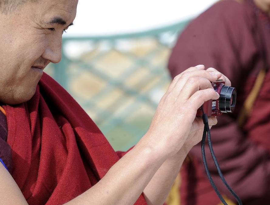 A lama takes photos for others at school in the Tibet College of Buddhism in Lhasa, capital of southwest China's Tibetan Autonomous Region, Nov. 7, 2011.