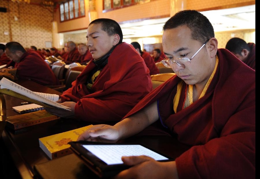 A lama student reads sutra doctrines on an Ipad in class in the Tibet College of Buddhism in Lhasa, capital of southwest China's Tibetan Autonomous Region, Nov. 7, 2011. 