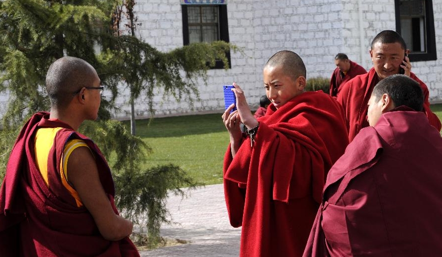 Lama students take photos for each other during a class break at school in the Tibet College of Buddhism in Lhasa, capital of southwest China's Tibetan Autonomous Region, Nov. 7, 2011. 