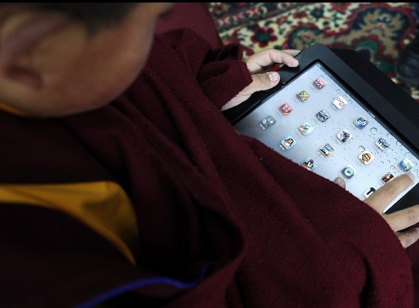 A lama student has fun with his Ipad at school in the Tibet College of Buddhism in Lhasa, capital of southwest China's Tibetan Autonomous Region, Nov. 7, 2011. 