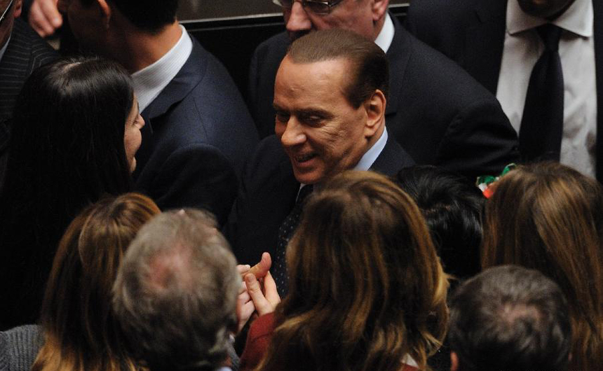 Italian Prime Minister Silvio Berlusconi is greeted by several lawmakers after a vote on the austerity measures for 2012 at the lower house of parliament in Rome, Italy, Nov. 12, 2011. Italian Prime Minister Silvio Berlusconi resigned Saturday night after a package of austerity measures demanded by the European Union (EU) was passed in both chambers of Italian parliament, the ANSA news agency reported. 