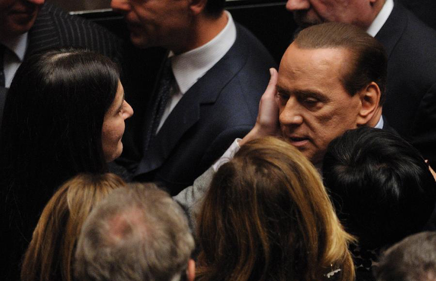 Italian Prime Minister Silvio Berlusconi is greeted by several lawmakers after a vote on the austerity measures for 2012 at the lower house of parliament in Rome, Italy, Nov. 12, 2011. Italian Prime Minister Silvio Berlusconi resigned Saturday night after a package of austerity measures demanded by the European Union (EU) was passed in both chambers of Italian parliament, the ANSA news agency reported.