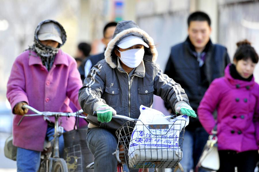 Citizens wearing thick clothes ride against wind in Shenyang, capital of northeast China's Liaoning Province, Nov. 13, 2011. A cold front hit the city on Sunday, with the lowest temperature dropped to seven degrees Centigrade below zero. 