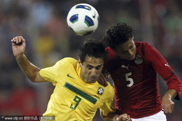  Brazil's Jonas Oliveira (left) fights for the ball with Egypt's Ibrahim Salah during their international friendly match in Doha, Qatar on Monday Nov. 14, 2011.