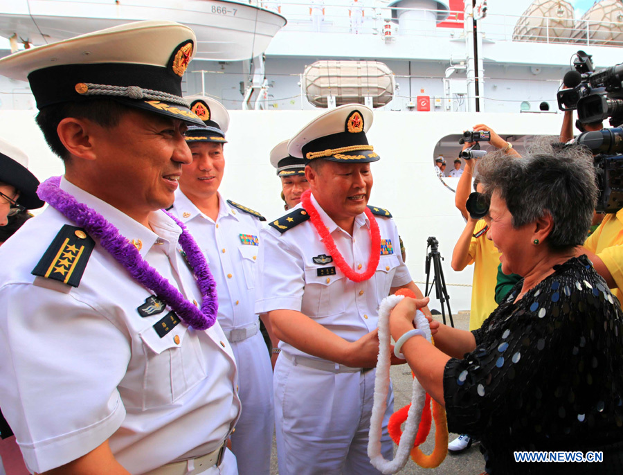 Liu Zhaomei(1st R), 71-year-old overseas Chinese, presents coronets of flowers to Qiu Yanpeng (2nd R), commander of the Chinese Navy &apos;Peace Ark&apos; hospital ship, before the ship departs from Port of Spain, Trinidad and Tobago, Nov. 15, 2011. The Chinese Navy &apos;Peace Ark&apos; hospital ship is heading for Costa Rica to continue the humanitarian medical services after concluding its seven-day mission in Trinidad and Tobago. [Zha Chunming/Xinhua]