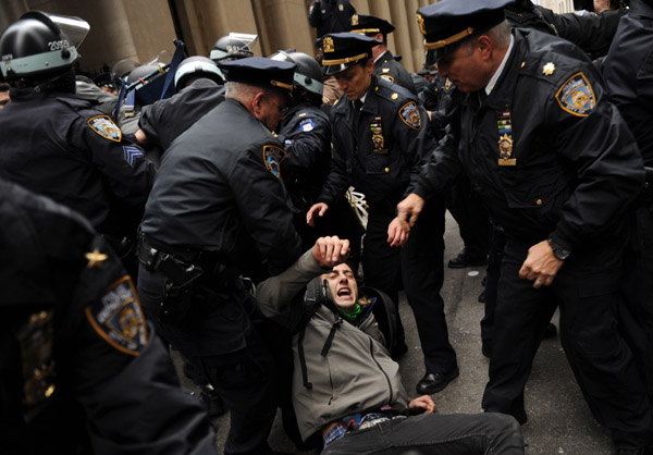 An Occupy Wall street demonstrator is arrested by the police as the protesters moving through the streets of Manhattan near the New York Stock Exchange in New York, Nov. 17, 2011. Hundreds of Occupy Wall Street protesters marched through New York's financial district toward the stock exchange on Thursday. [Shen Hong/Xinhua]