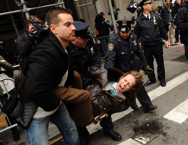 An Occupy Wall street demonstrator is arrested by the police as the protesters moving through the streets of Manhattan near the New York Stock Exchange in New York, Nov. 17, 2011. Hundreds of Occupy Wall Street protesters marched through New York's financial district toward the stock exchange on Thursday. [Shen Hong/Xinhua]