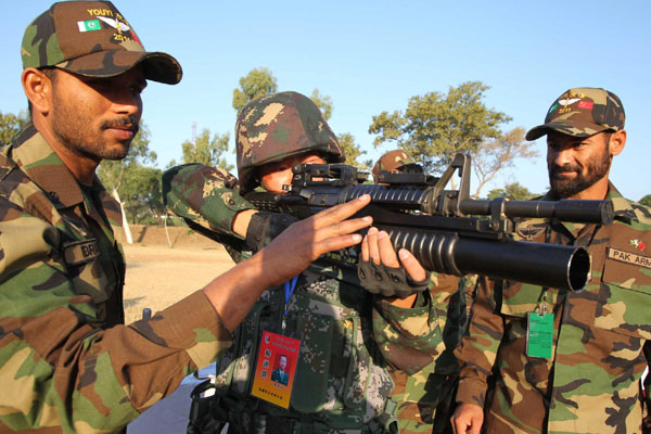 A Chinese soldier holds a rifle from the Pakistani army, aiming at a target on the first day of the 'Friendship 2011' joint anti-terror exercise in Mangla, near Islamabad in Pakistan, Nov 17, 2011. [Xinhua] 