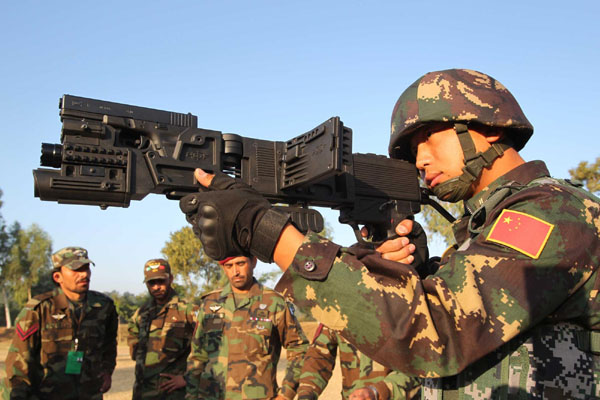 A Chinese soldier holds a rifle from the Pakistani army, aiming at a target on the first day of the 'Friendship 2011' joint anti-terror exercise in Mangla, near Islamabad in Pakistan, Nov 17, 2011. [Xinhua]