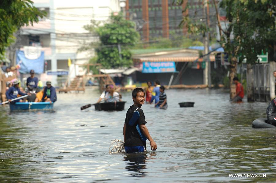 A man walks in the floodwaters in Bang Khun Thian district in Bangkok, Thailand, Nov. 18, 2011. A total of 595 people were confirmed dead and two people were still missing in the floods that have inundated many provinces for more than three months, Thai Disaster Prevention and Mitigation Department reported on Friday. [Rachen Sageamsak/Xinhua]