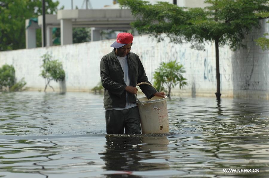 A man walks in the floodwaters in Bang Khun Thian district in Bangkok, Thailand, Nov. 18, 2011. A total of 595 people were confirmed dead and two people were still missing in the floods that have inundated many provinces for more than three months, Thai Disaster Prevention and Mitigation Department reported on Friday. [Rachen Sageamsak/Xinhua]